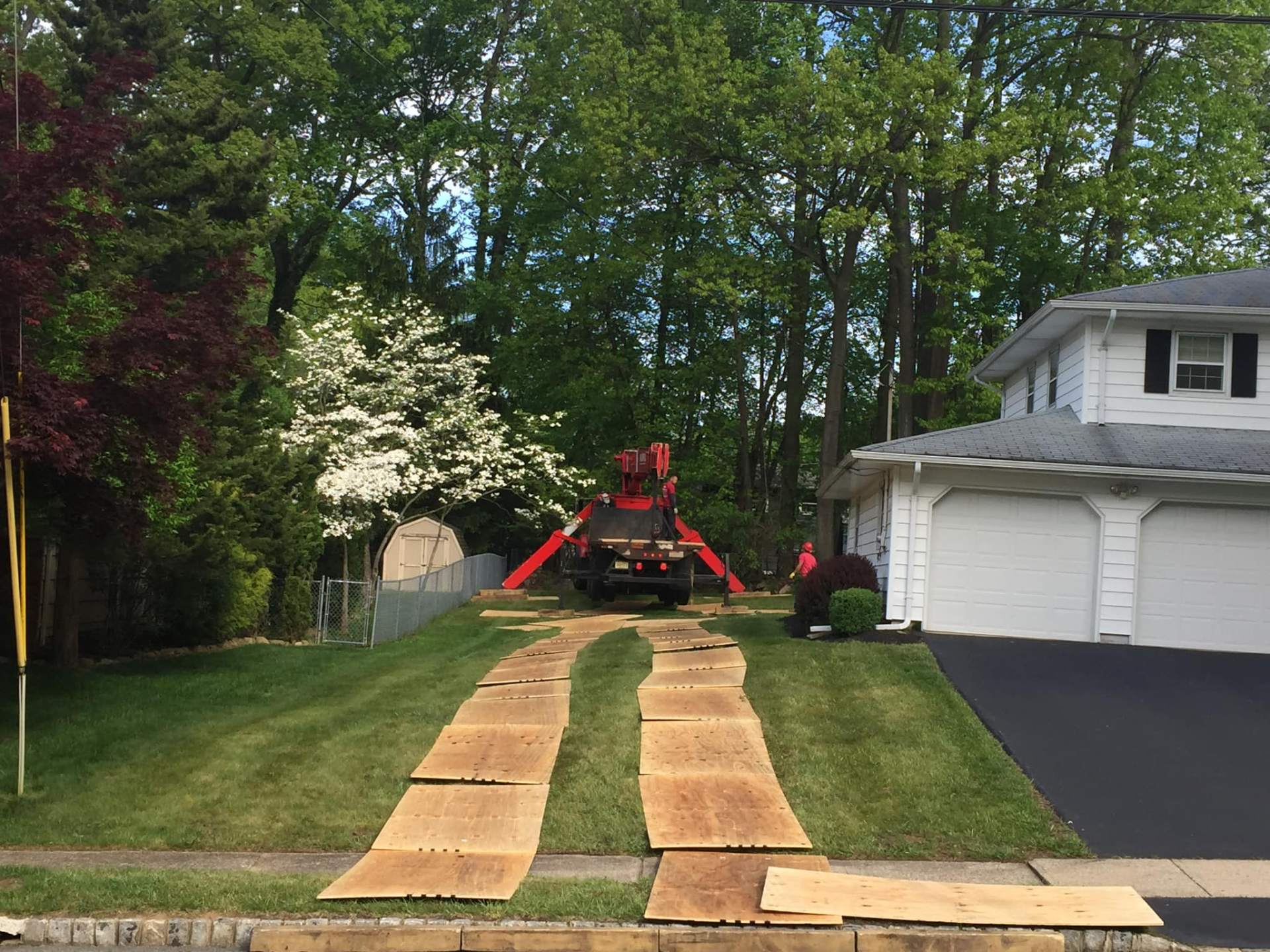Crane setup with lawn protection and crew working