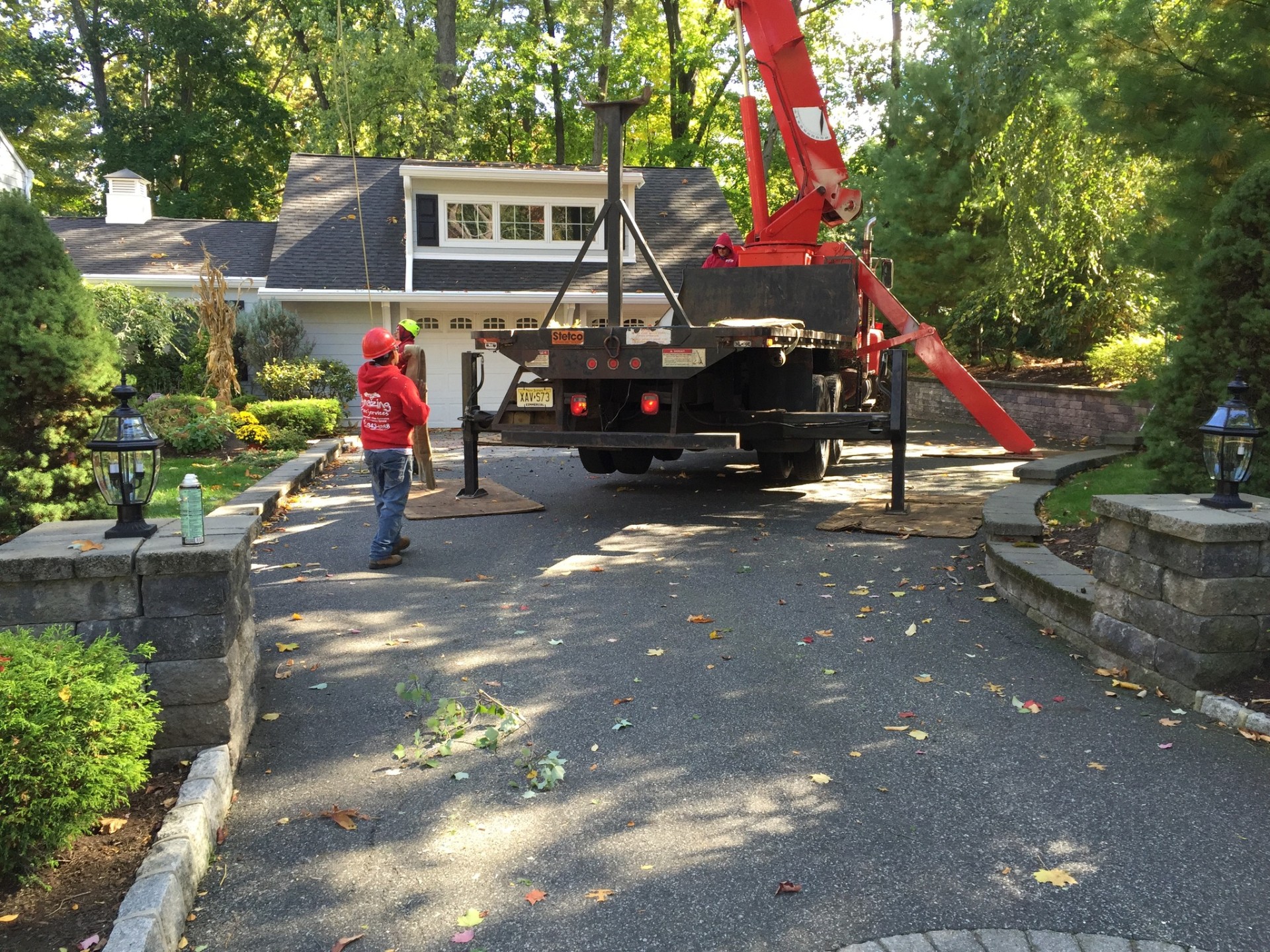 Crane set up on residential driveway for tree removal